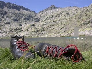 Botas sobre hierba y montañas en la Sierra de Gredos